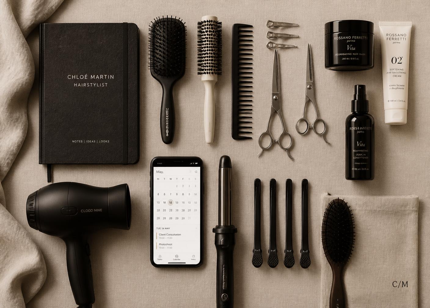 Hairstylist kit laid out with tools, notebook and a phone calendar